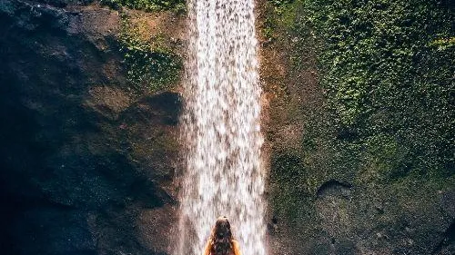 Sunbeam of light piercing through the cave opening above Tukad Cepung Waterfall in Bali Ubud on a private scenic waterfalls and rice terraces tour
